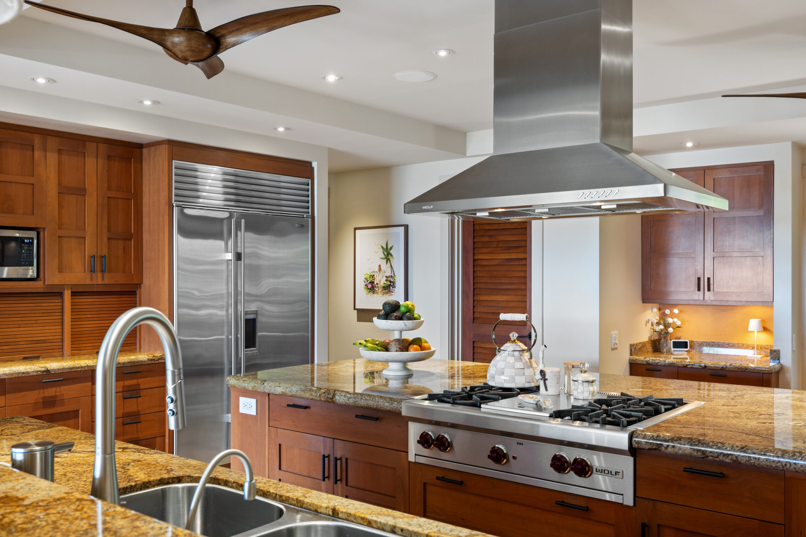 Gourmet kitchen with island cooktop, large refrigerator, double ovens, two dishwashers, and ample counter space