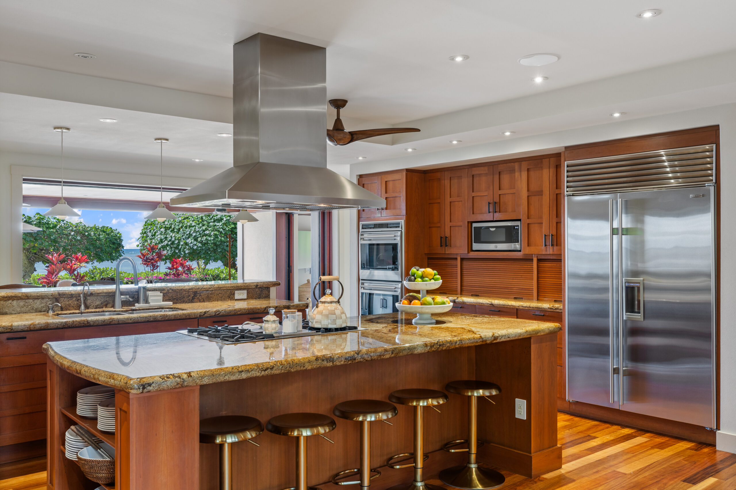 Gourmet kitchen with island cooktop, large refrigerator, double ovens, two dishwashers, and ample counter space