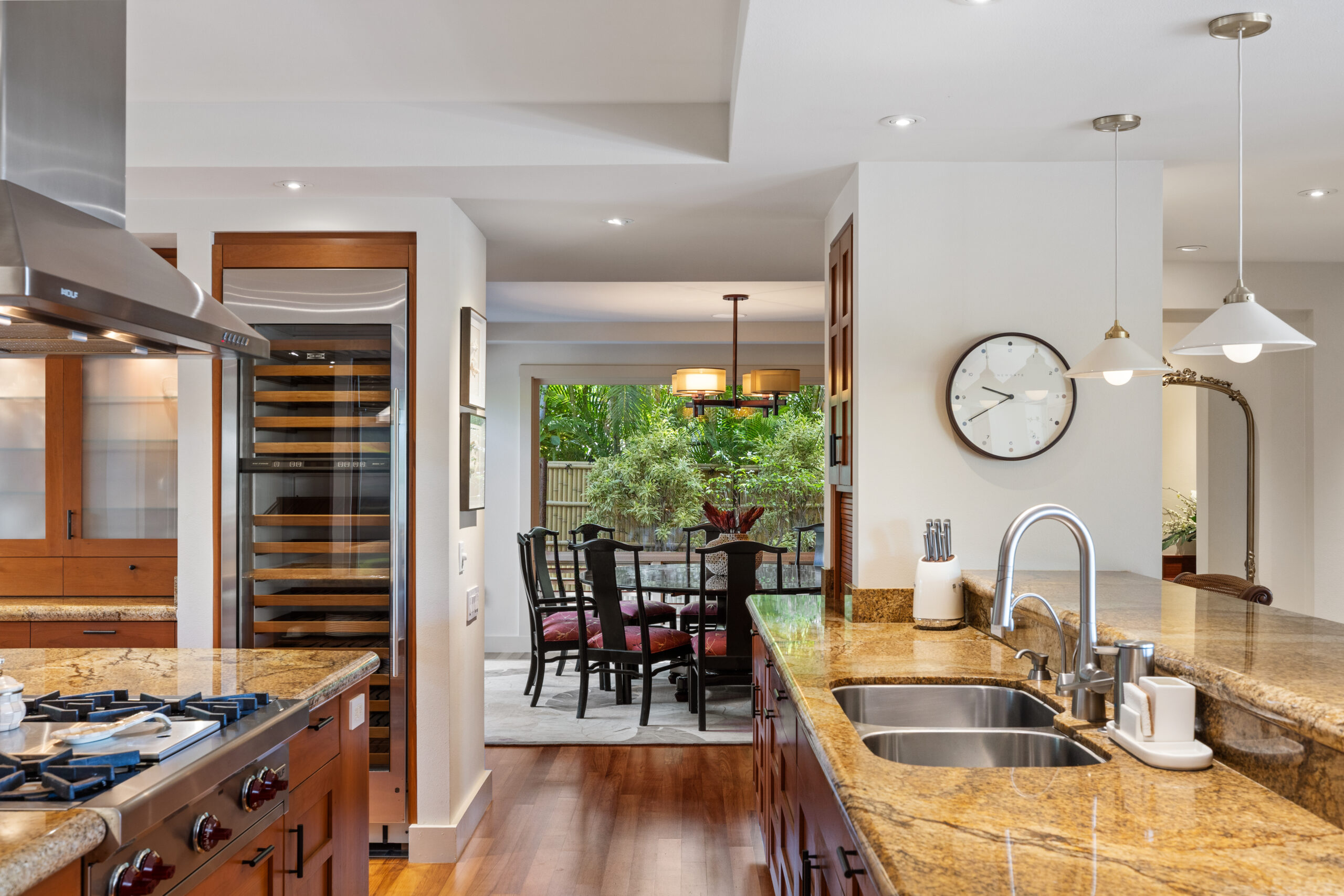 Gourmet kitchen with premium appliances and wood cabinetry, overlooking round dining table seating ten