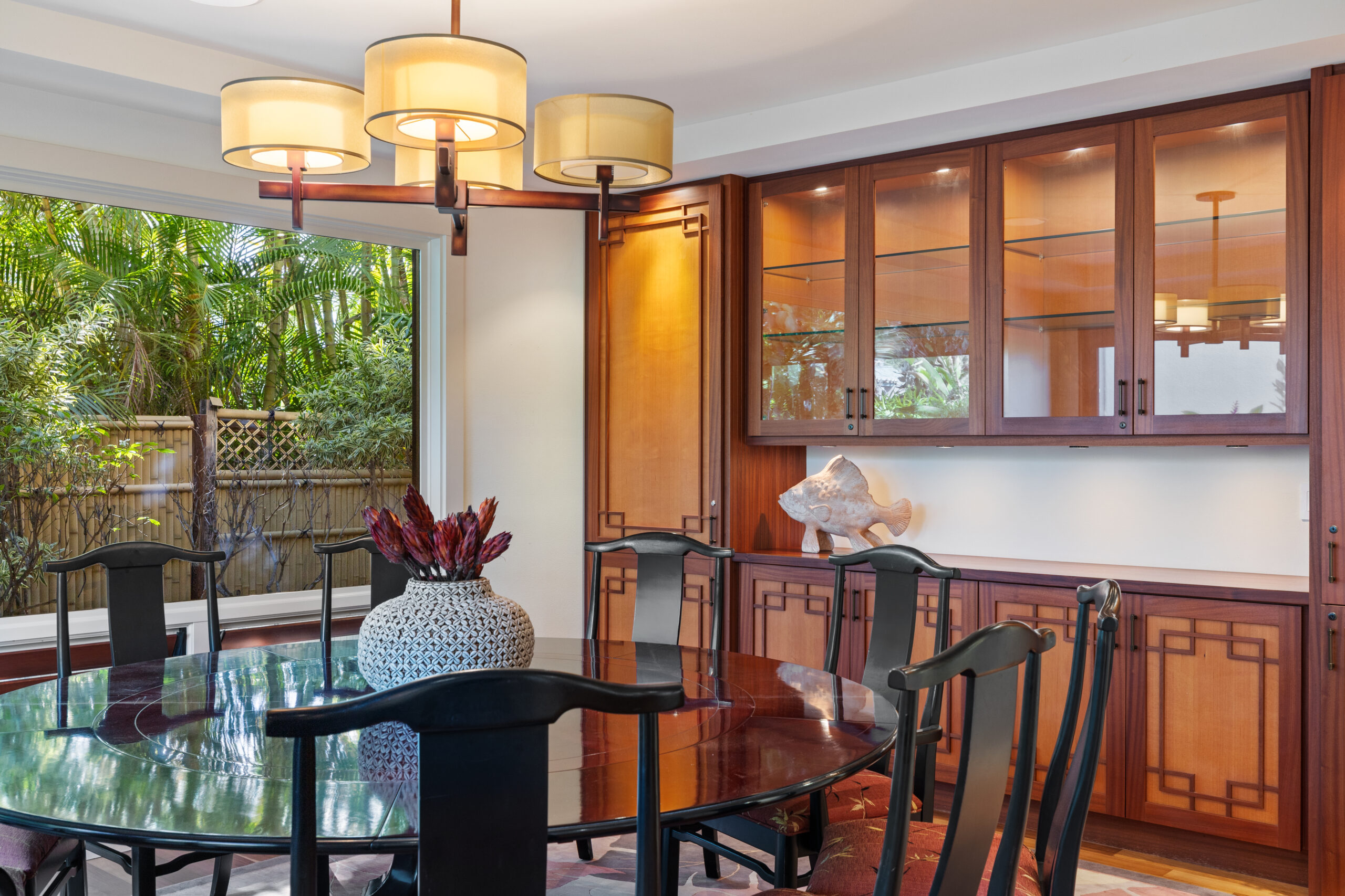 Indoor dining room with round table seating ten, surrounded by custom wood cabinetry and soft lighting