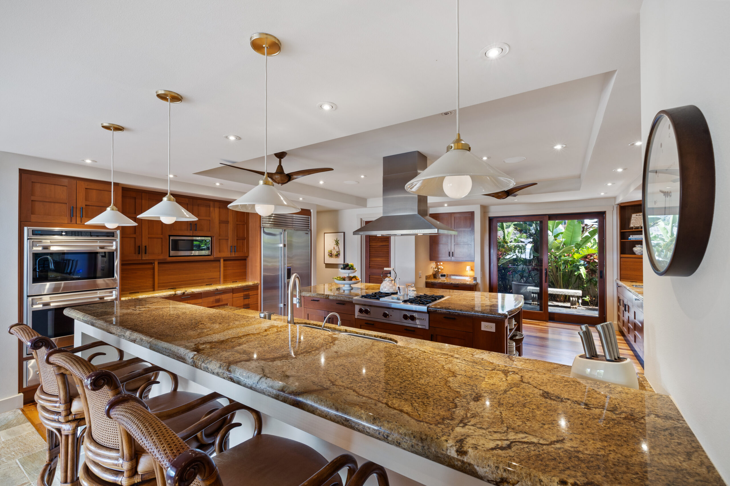 Gourmet kitchen with island cooktop, large refrigerator, double ovens, two dishwashers, and ample counter space
