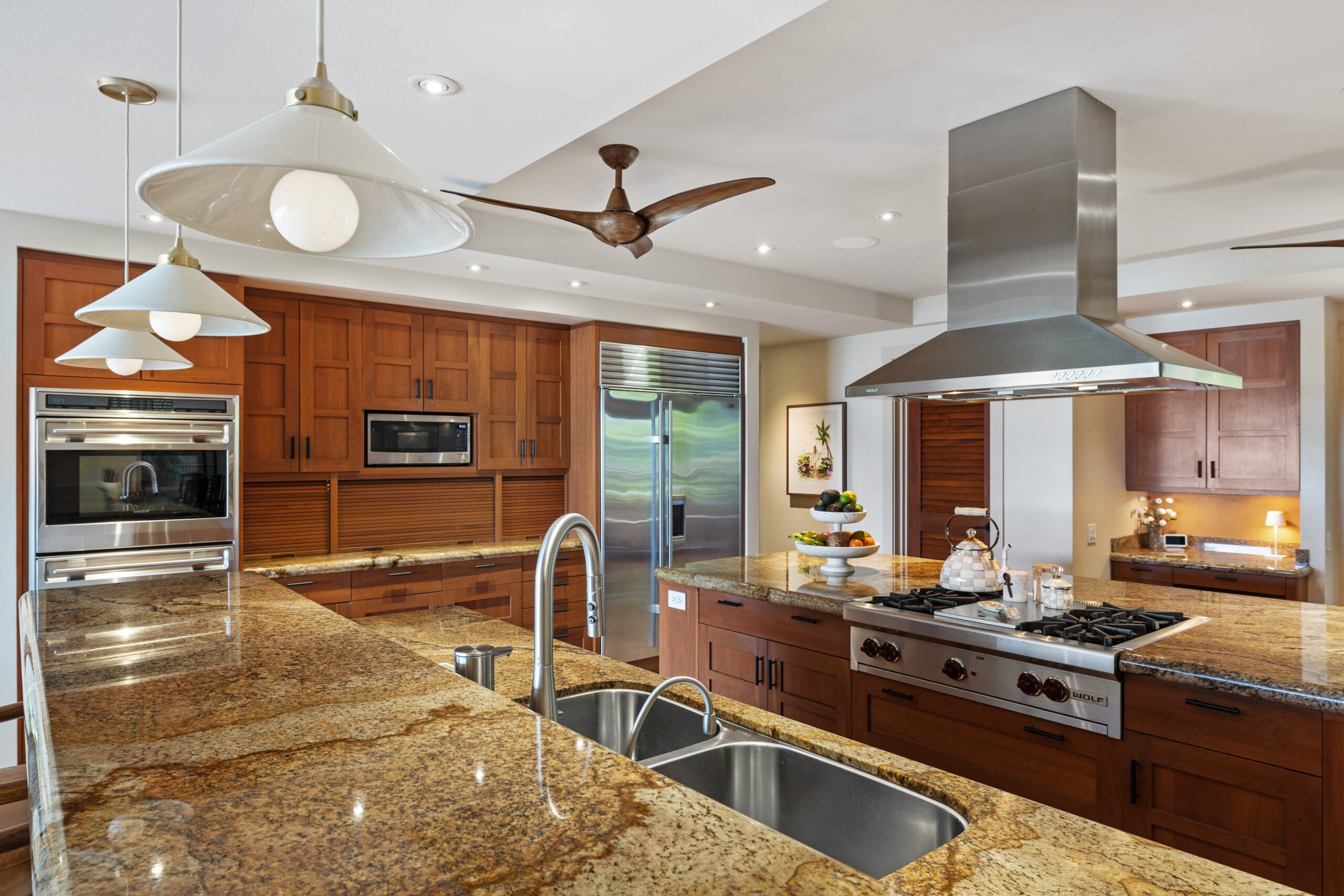 Gourmet kitchen with island cooktop, large refrigerator, double ovens, two dishwashers, and ample counter space