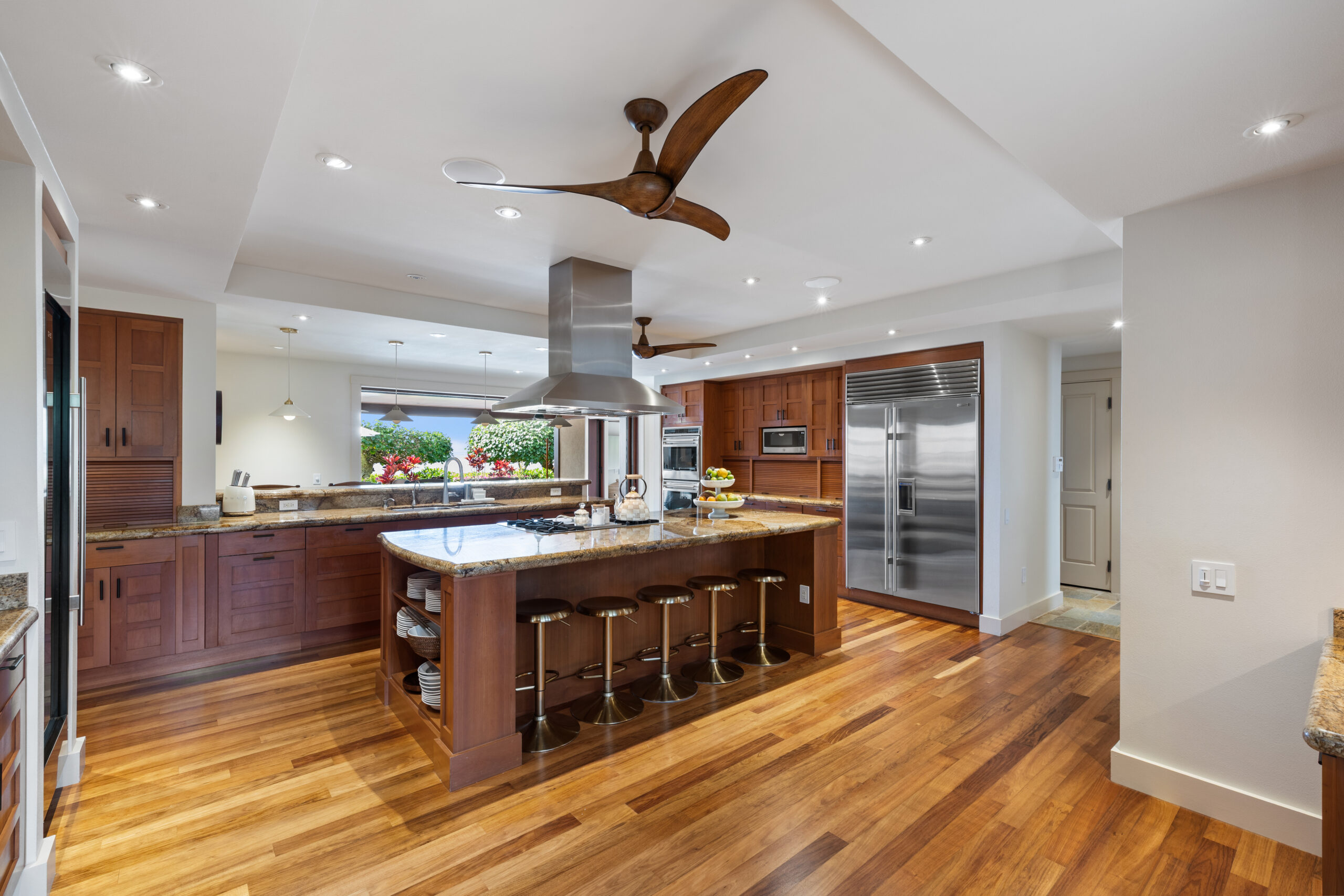 Gourmet kitchen with island cooktop, large refrigerator, double ovens, two dishwashers, and ample counter space