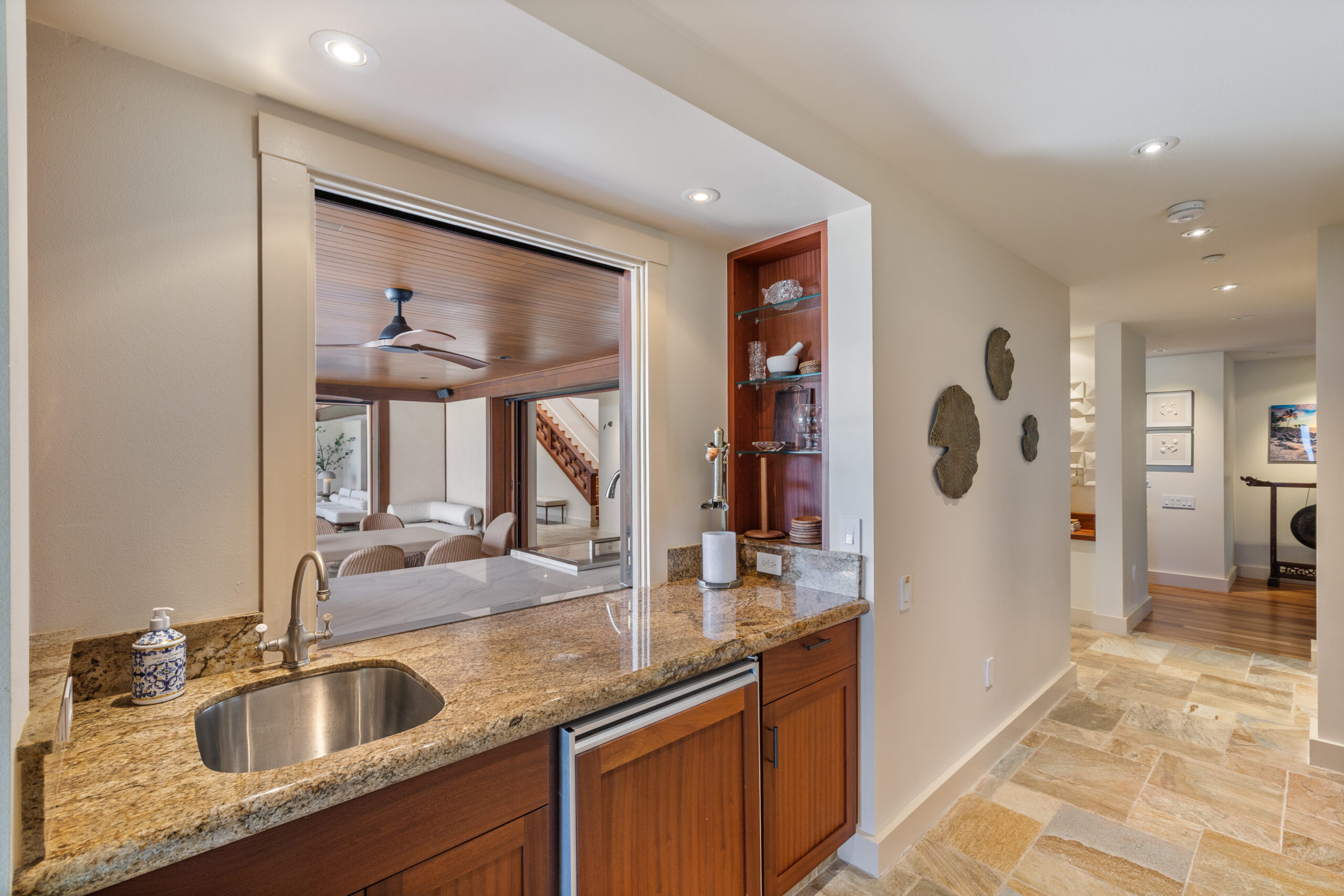 Indoor/outdoor kitchen with bar window pass-through, premium appliances, and open-air layout for tropical entertaining