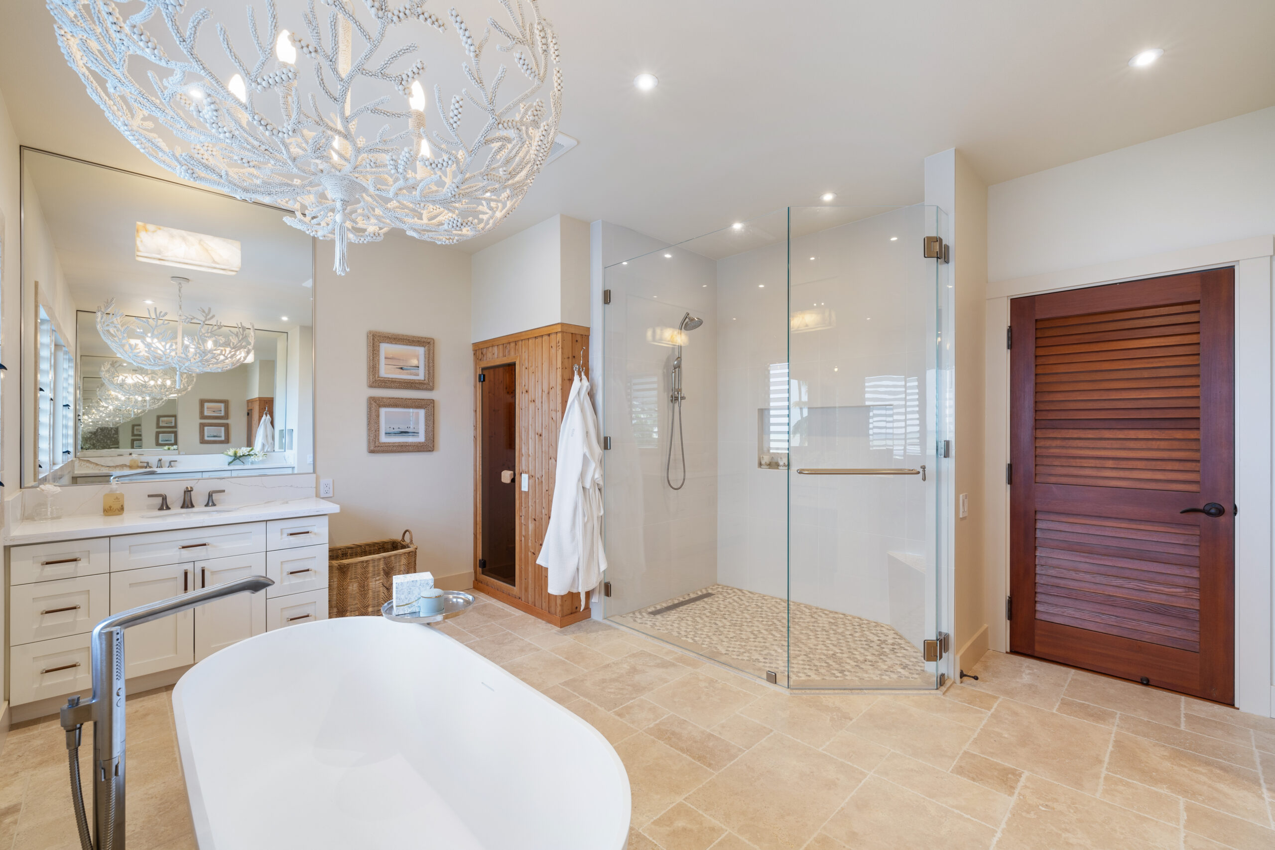 Luxurious spa bathroom featuring freestanding soaker tub, glass-enclosed oversized shower, coral chandelier, dual vanity, and wooden sauna with travertine tile flooring.